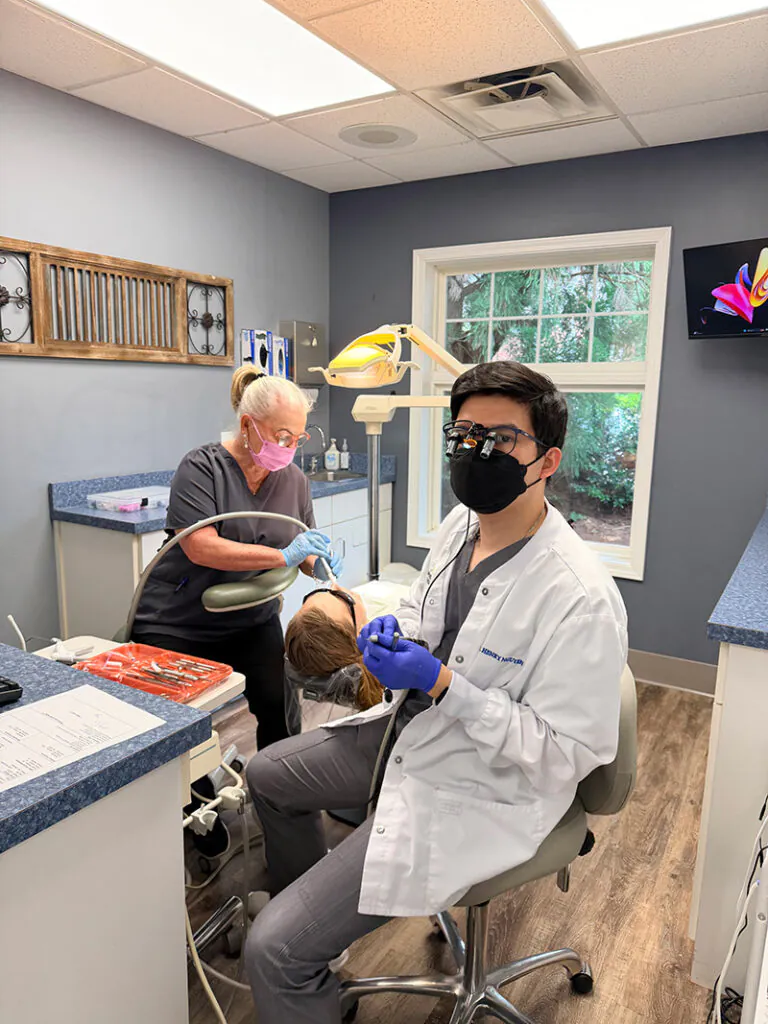 Henry H. Nguyen, DMD performing a restorative dentistry procedure with his dental assistant